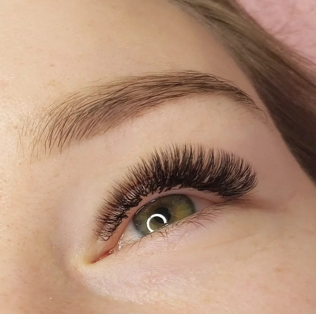 Auge mit dichter Wimpernverlängerung im Volumen-Look, seitlich fotografiert